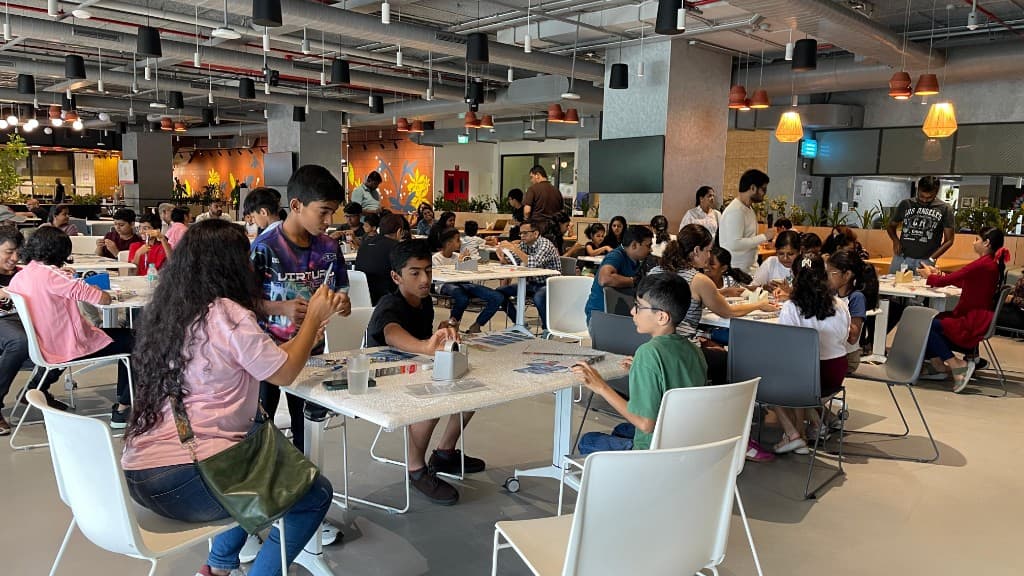 Families working together at tables in a workshop hall