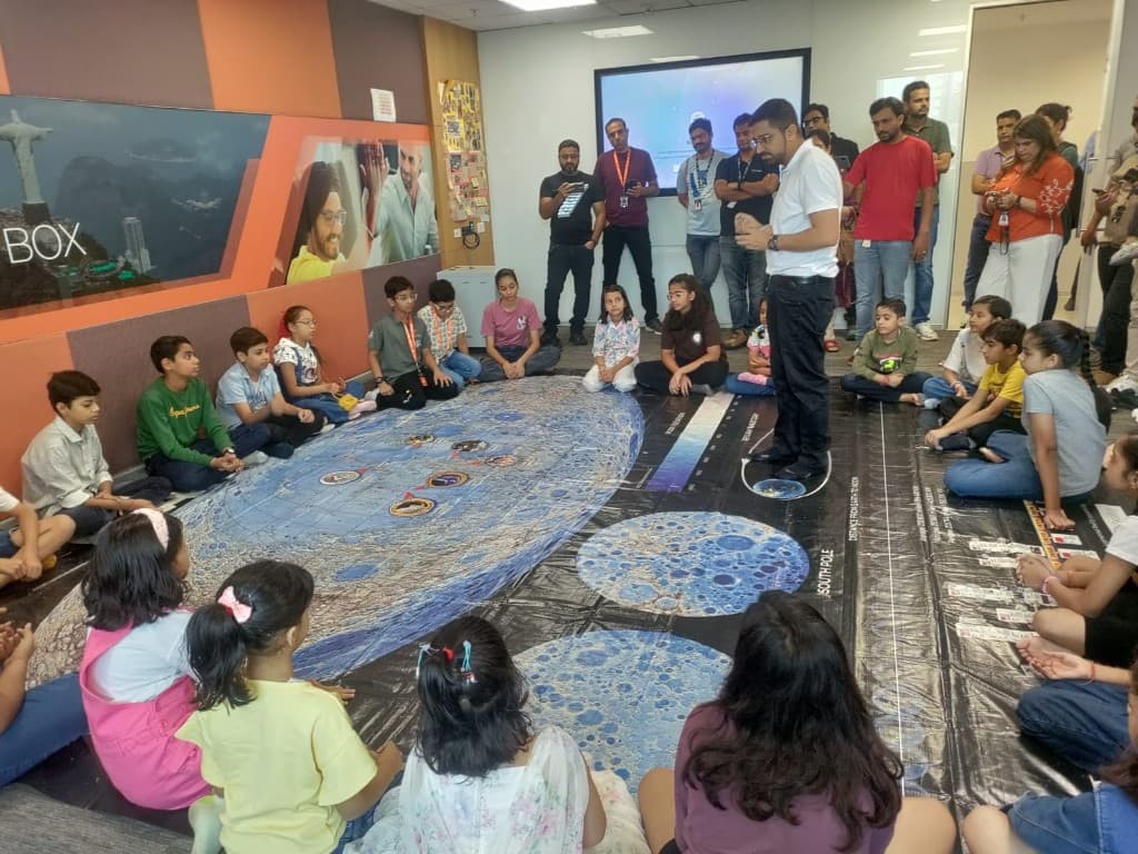 Children gathered around a large Moon map during a session
