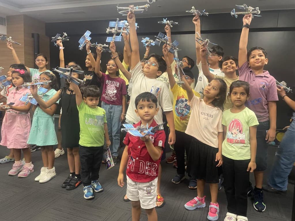 Children holding up model satellites at a workshop
