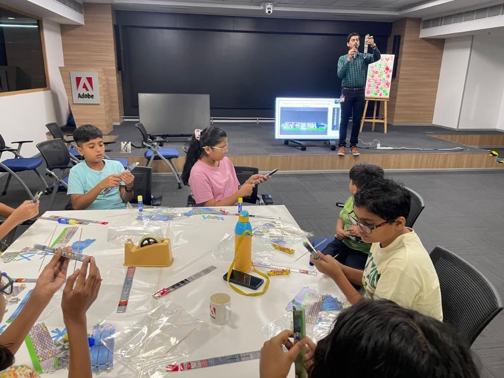 Children building models while a facilitator presents